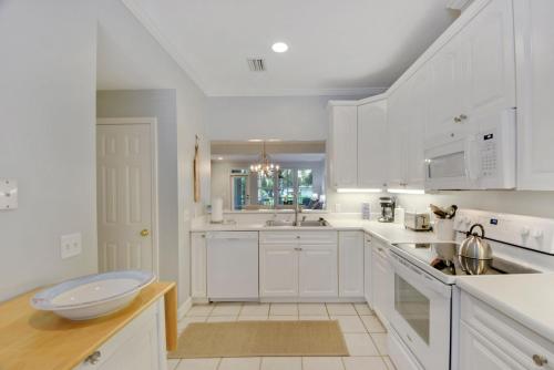 a white kitchen with white cabinets and a sink at Low Country in Harrington