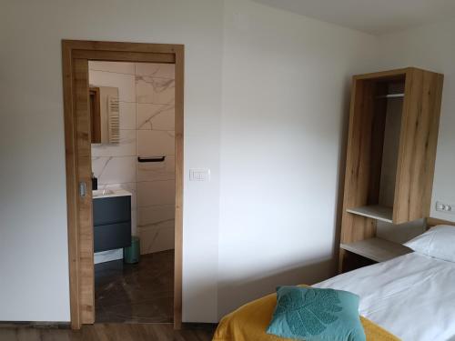 a room with a bedroom with a bed and a bathroom at Apartmaji Hodak in Bohinj