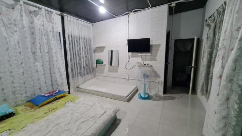 een slaapkamer met een bed en een tv in een kamer bij บ้านแม่ in Ban Nam Tok Mae Klang