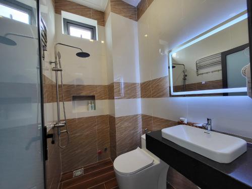 a bathroom with a sink and a toilet and a mirror at RUBY HOTEL Vĩnh Long in Vĩnh Long