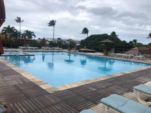 uma grande piscina azul com cadeiras e palmeiras em Maui El Dorado Kaanapali Beach Studio- G204 em Kahana