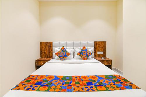 a bedroom with a bed with a colorful comforter at FabHotel The Hastings Club in Kolkata