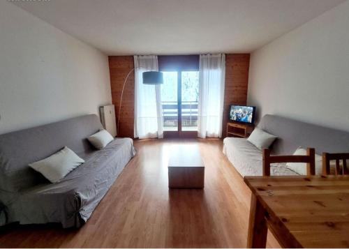 een woonkamer met een bank en een tafel bij Appartement Spacieux aux Portes du Soleil in Torgon