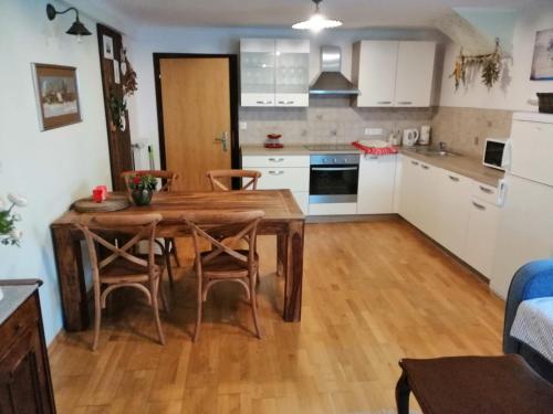 a kitchen and dining room with a wooden table and chairs at Barn House MM in Bled