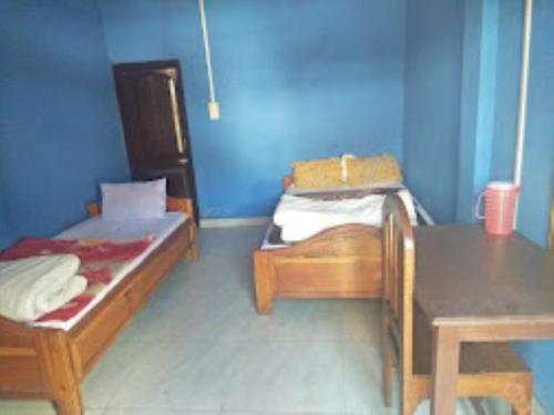 a small room with two beds and a table at Hotel Dirang Buddha Dirang in Dirang Dzong