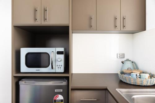 a microwave oven sitting inside of a kitchen at MAC St Kilda by Melbourne Apartment Collection in Melbourne