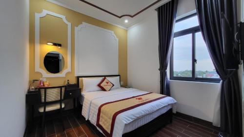 a small bedroom with a bed and a window at RUBY HOTEL Vĩnh Long in Vĩnh Long