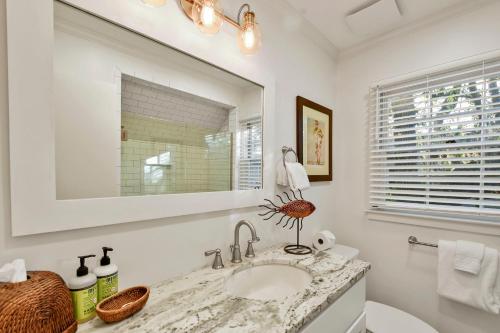 a white bathroom with a sink and a mirror at Oceanwood 106 in Saint Simons Island