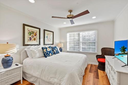 a bedroom with a bed and a ceiling fan at Oceanwood 106 in Saint Simons Island