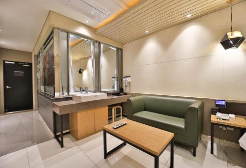 uma casa de banho com uma cadeira verde e um lavatório em Pohang A1 Jukdo em Pohang