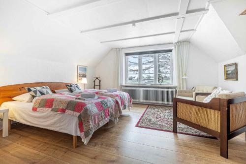 sypialnia z łóżkiem, krzesłem i oknem w obiekcie Stately Apartment Incl, Consumption w mieście Bogense