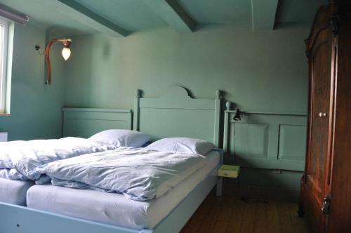 a bed with white sheets and pillows in a room at Ferienhaus EMMA in Kleinern