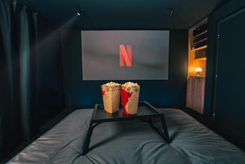 two drinks on a table on a bed in a room at Cinéma ROOM l'unique expérience by Noma in Saint-Étienne