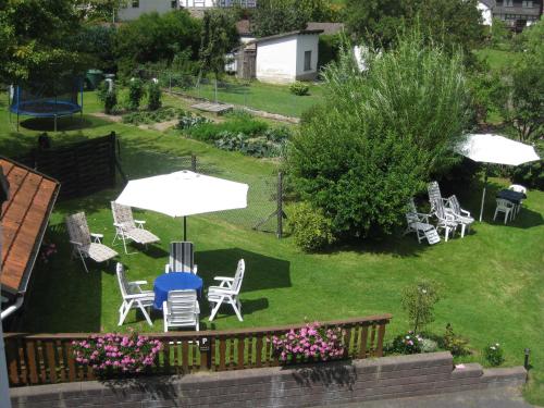 a group of chairs and umbrellas on a lawn at Haus Bergblick in Bringhausen