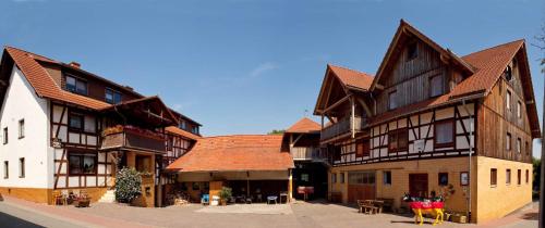 un grupo de edificios de madera con techos marrones en Bauernhofpension Büchsenschütz, en Harbshausen