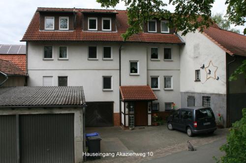 un coche aparcado frente a una casa blanca en Ferienwohnung Hamel, en Kirchlotheim