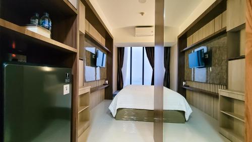 a bedroom with a bed in a room at Palam Mansion at Meisterstadt Pollux Habibie Apartment in Batam Center