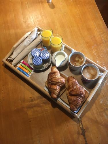 una bandeja de bollería y otros alimentos para el desayuno en una mesa en la chambre de l'auxineill, en Castelnou