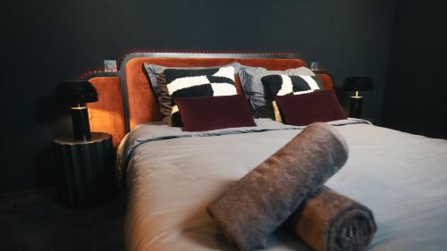 um quarto com uma cama com almofadas em Cinéma ROOM l'unique expérience em Saint-Étienne