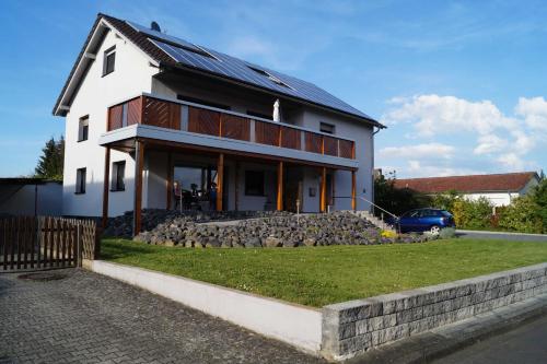 een groot wit huis met een stenen muur bij Ferienwohnung am Eckerich in Fritzlar