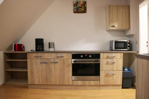 a kitchen with a stove and a microwave at Ferienwohnung Seerose in Hemfurth-Edersee