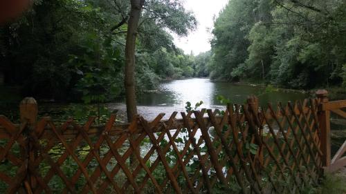 a fence in front of a river with a river at Chalupy Majer Biffar in Dunajský Klátov