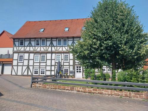 a building with a tree and a bench in front of it at Ferienwohnung "Zum Alten Römer" in Kleinern