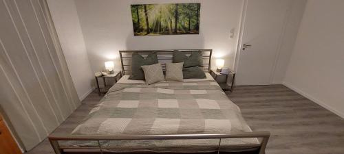 um quarto com uma cama grande e 2 candeeiros em Ferienhaus Mauersegler em Hemfurth-Edersee