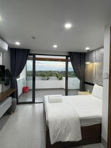 1 dormitorio con 1 cama grande y balcón en Lagi Beach Hotel, en La Gi