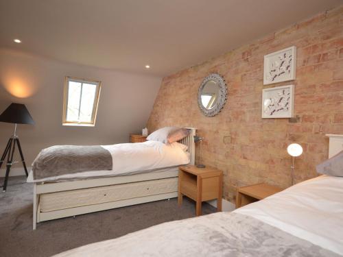 a bedroom with two beds and a brick wall at 2 bed in Alford 42581 