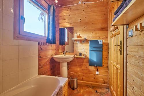 a bathroom with a sink and a tub and a toilet at Le chalet Céline in Le Dévoluy