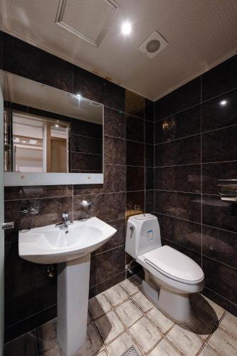 a bathroom with a sink and a toilet and a mirror at BELMORE Hotel in Busan