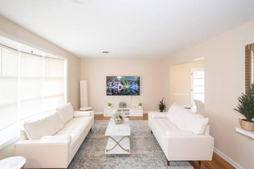 a living room with white furniture and a large window at Home in College Park in College Park