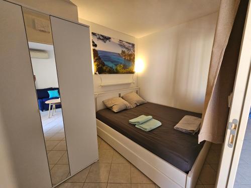 - un petit lit dans une petite chambre avec un miroir dans l'établissement T2 neuf et calme au cœur de Sanary avec terrasse et box, à Sanary-sur-Mer