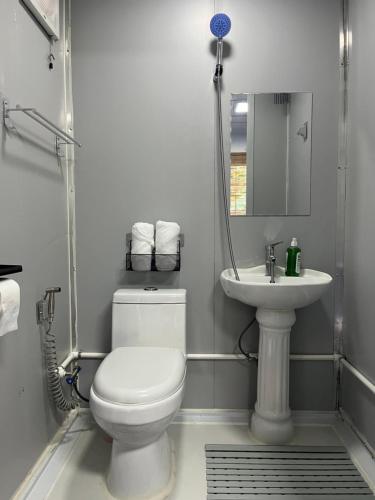 a white bathroom with a toilet and a sink at Ysla Cabins in Cabangan