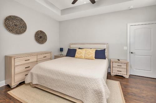 a white bedroom with a bed and two dressers at Island Retreat in Glynn Haven in Saint Simons Island