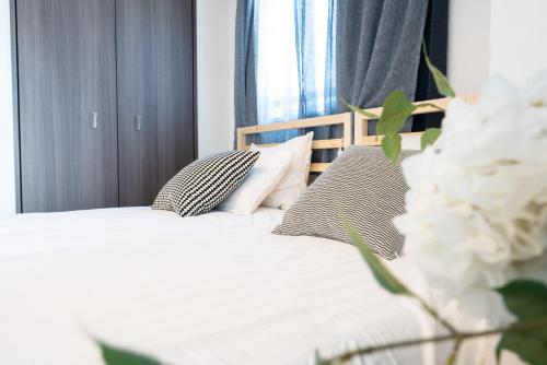 a bedroom with a white bed with pillows and a window at Nippori Bristol Hotel in Tokyo