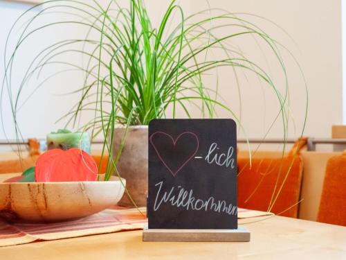 a chalkboard sign on a table with a plant at Apartment in Niedernsill near Ski Slopes in Niedernsill