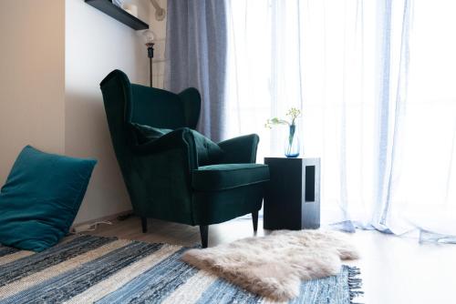 a living room with a green chair and a rug at Nippori Bristol Hotel in Tokyo
