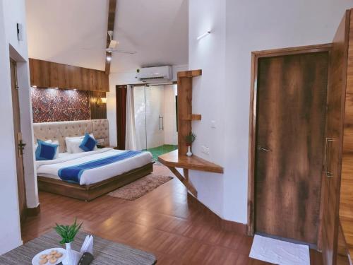 a bedroom with a bed and a table in a room at Royals Moonlight Resort,Corbett in Rāmnagar