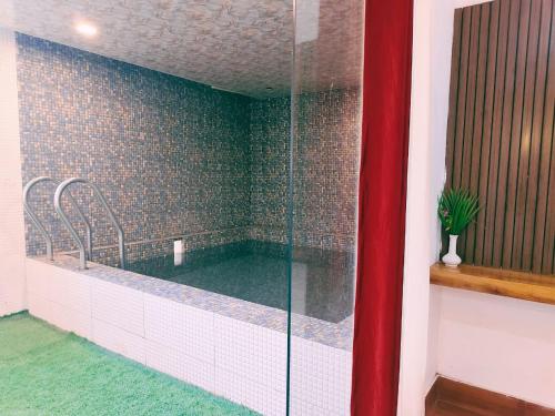 a bathroom with a tub with a glass shower at Royals Moonlight Resort,Corbett in Rāmnagar