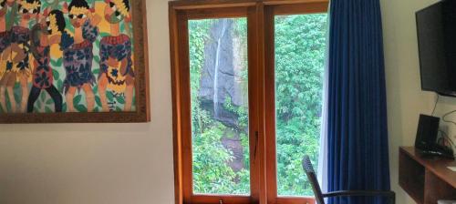 una ventana en una habitación con vistas a los árboles en Villa Biyu Siyu, en Ubud