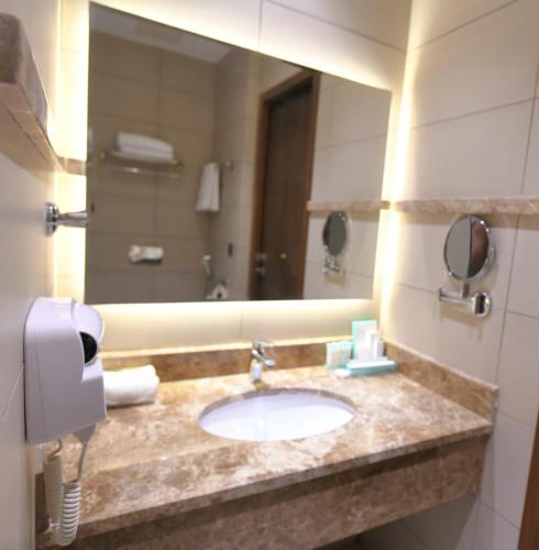 a bathroom with a sink and a mirror at Renee Hotel in Jeddah