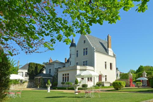 een groot wit huis met een tuin met tafels bij Le Manoir Saint Thomas in Amboise
