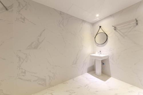 a white bathroom with a sink and a mirror at HOUND HOTEL sasang branch in Busan