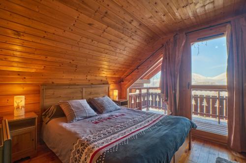 1 dormitorio con 1 cama en una habitación de madera con ventana en Le chalet Sylvaine, en Le Dévoluy