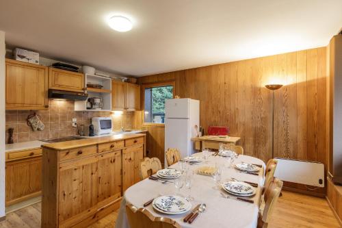 une cuisine avec une table et des chaises et un réfrigérateur blanc dans l'établissement Residence Montana 3 Chambres - Happy Rentals, à Chamonix-Mont-Blanc