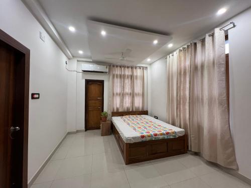 ein Schlafzimmer mit einem Bett in der Mitte eines Zimmers in der Unterkunft Shrinath Palace in Deoghar