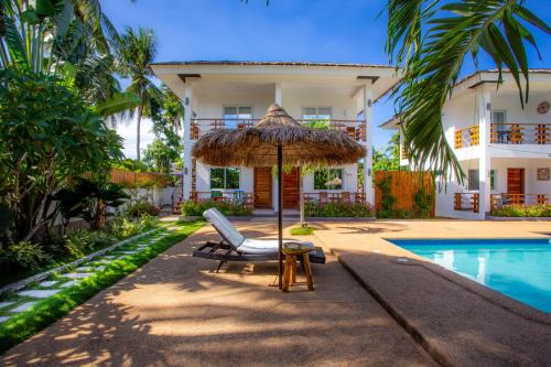 een stoel en een parasol naast een zwembad bij Dolce Amore Resort in Siquijor