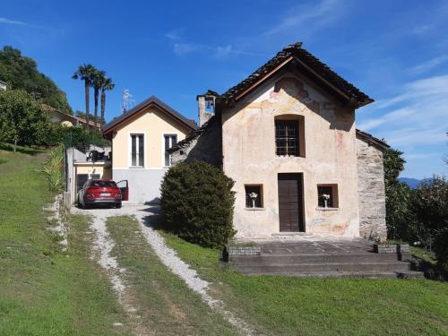 a house with a car parked in front of it at Casa giardino panoramico in Cannero Riviera